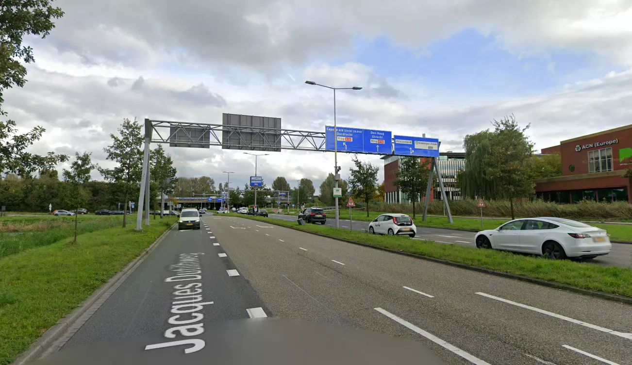 Politievoertuigen met zwaailichten staan geparkeerd bij een afzetting op de Jacques Dutilhweg in Rotterdam, waar forensisch onderzoekers in de nacht sporenonderzoek doen na een schietincident.
