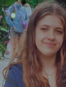 Politiefoto van de vermiste 14-jarige Demi-Lee uit Den Haag. Zij heeft donkerblond haar, groene ogen en draagt een opvallende lichtblauwe spijkerbroek met gaten op de knieën.