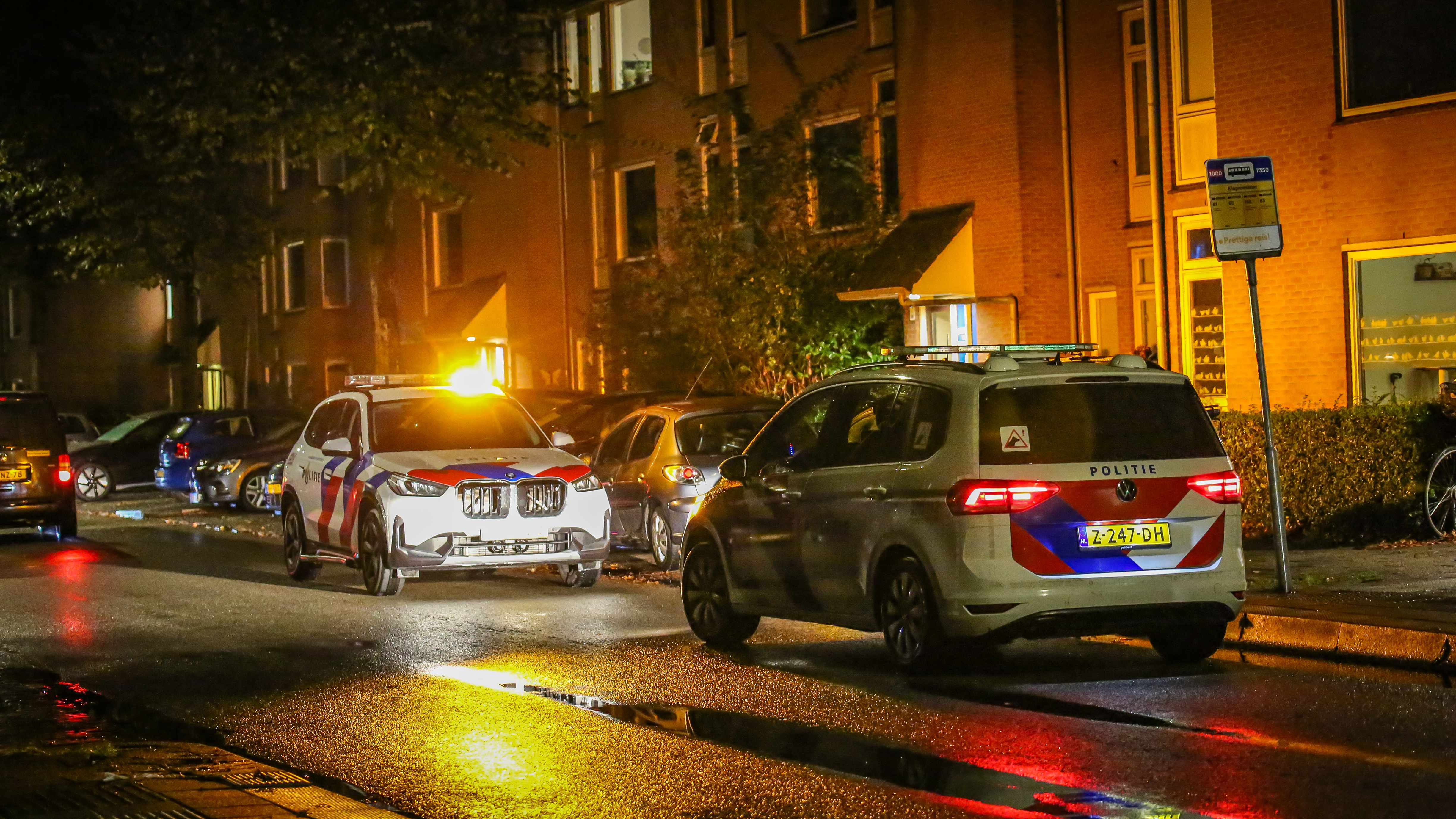 Zwaailichten van politieauto's en een ambulance in de nacht aan de Zaagmuldersweg in Groningen.