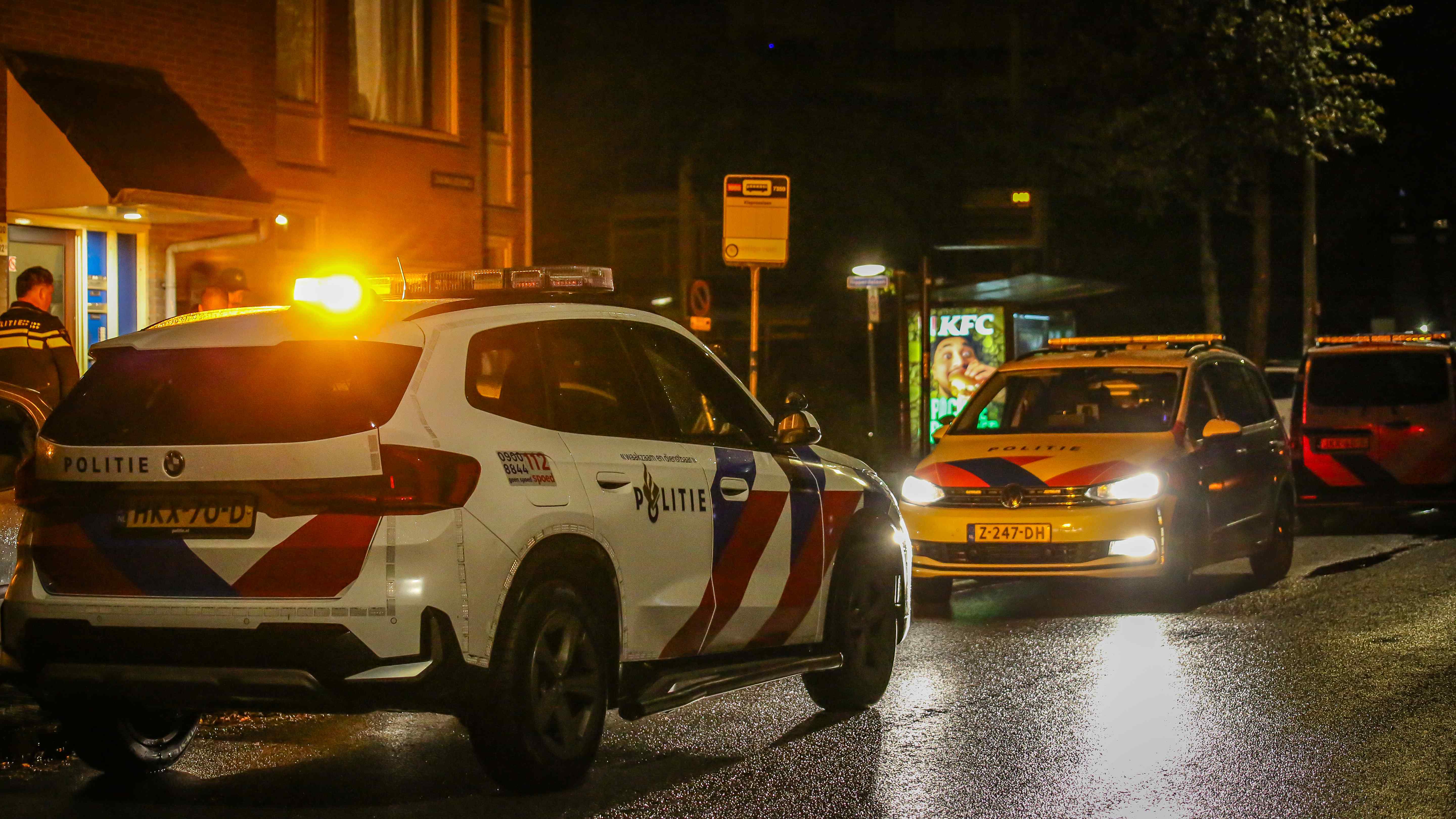 Zwaailichten van politieauto's en een ambulance in de nacht aan de Zaagmuldersweg in Groningen.