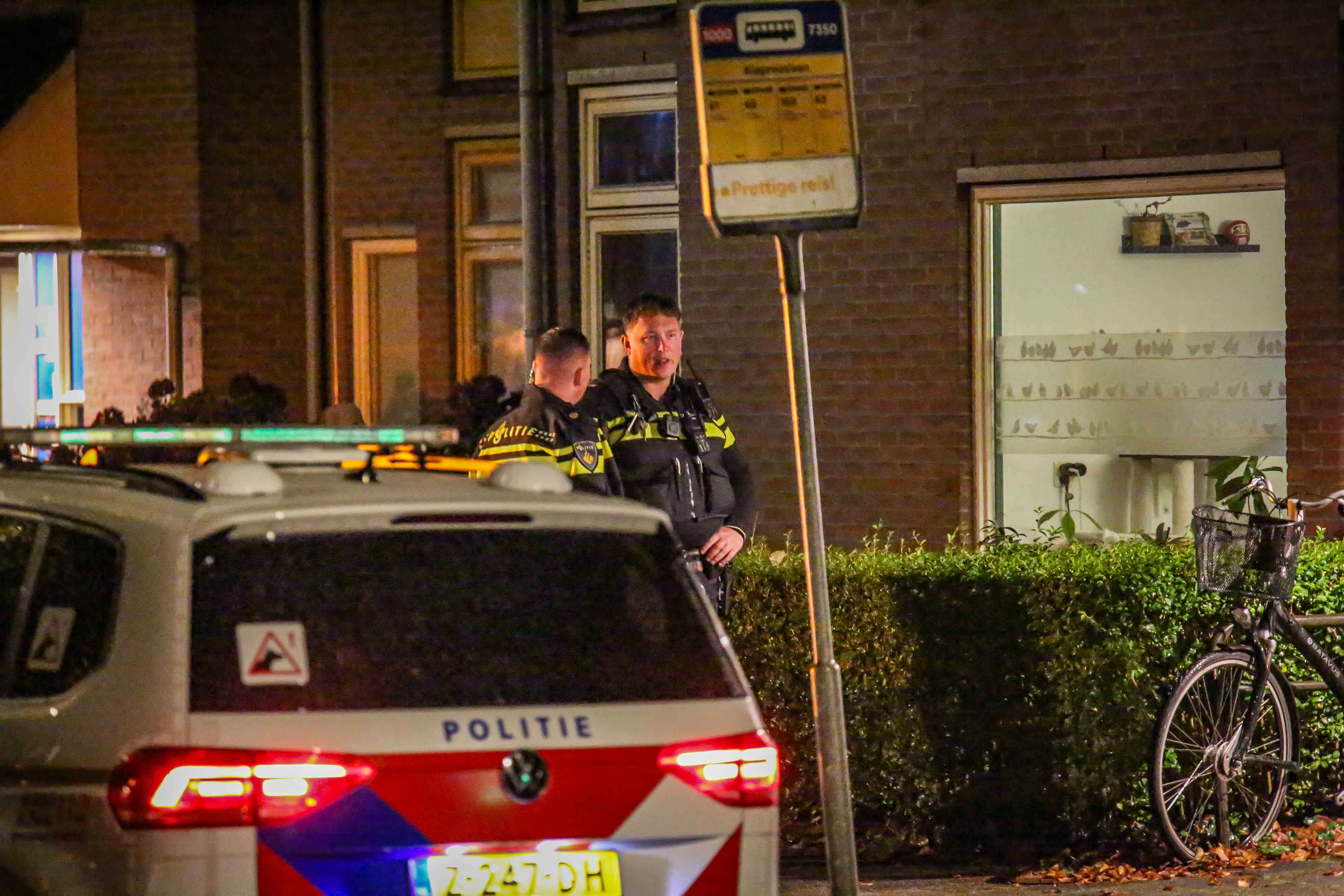 Zwaailichten van politieauto's en een ambulance in de nacht aan de Zaagmuldersweg in Groningen.