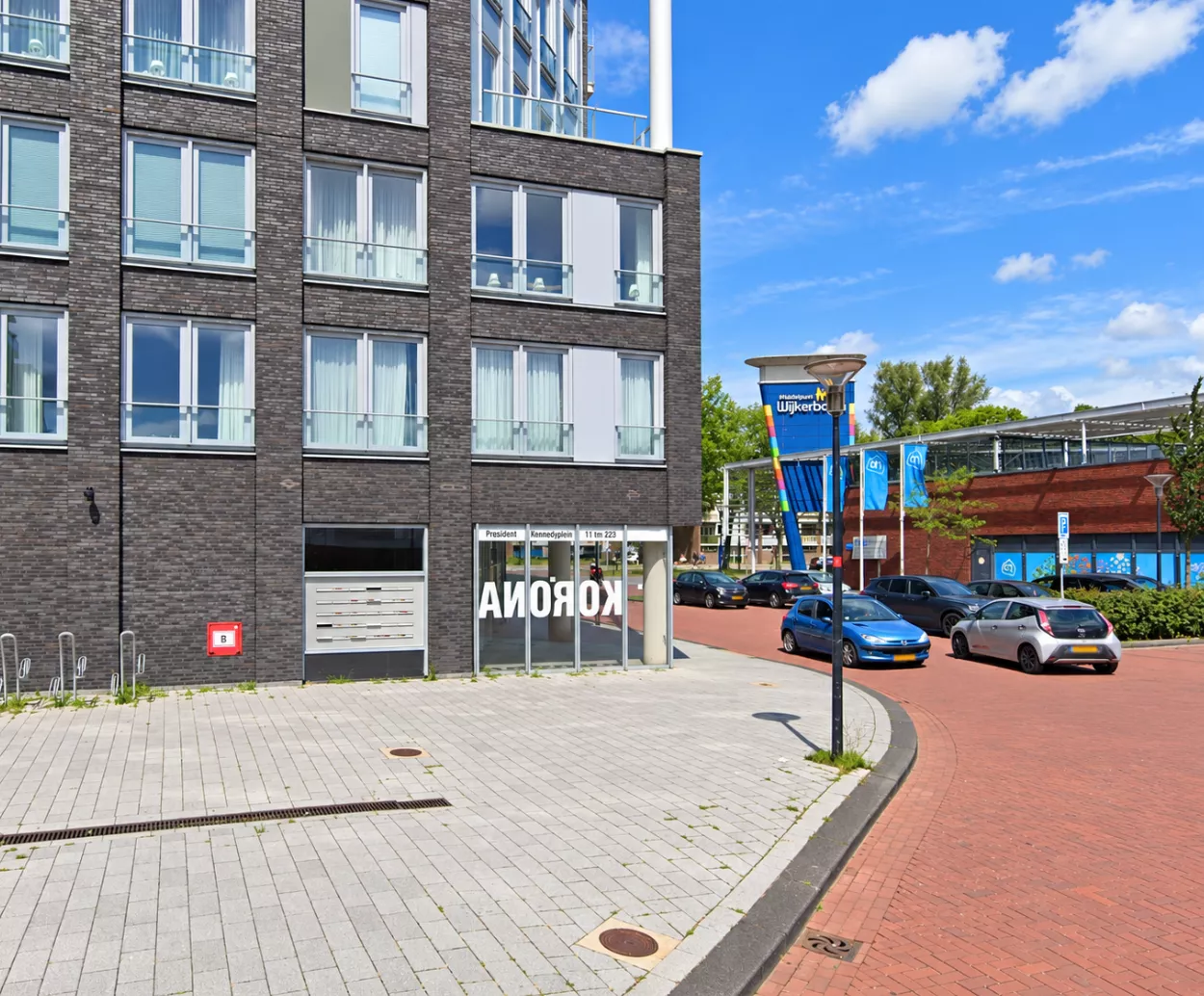 Straatnaambord President Kennedyplein in Beverwijk met politiewagen op de achtergrond.