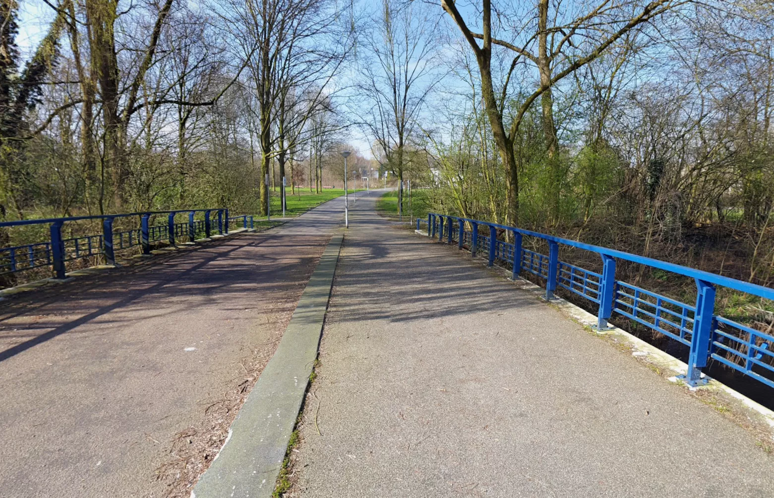 De opvallende blauwe brug in het Piet Wiedijkpark in Amsterdam, nabij de locatie waar de twee Syrische jongens werden doodgeschoten.