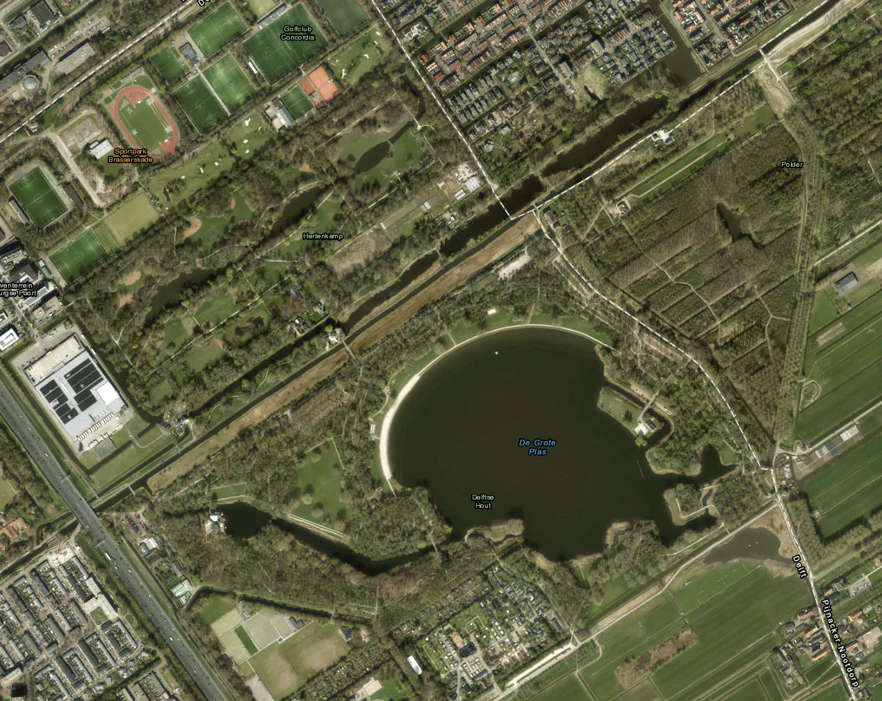 Een donker fietspad langs het water in recreatiegebied de Delftse Hout, de omgeving waar de nachtelijke incidenten zich afspeelden.