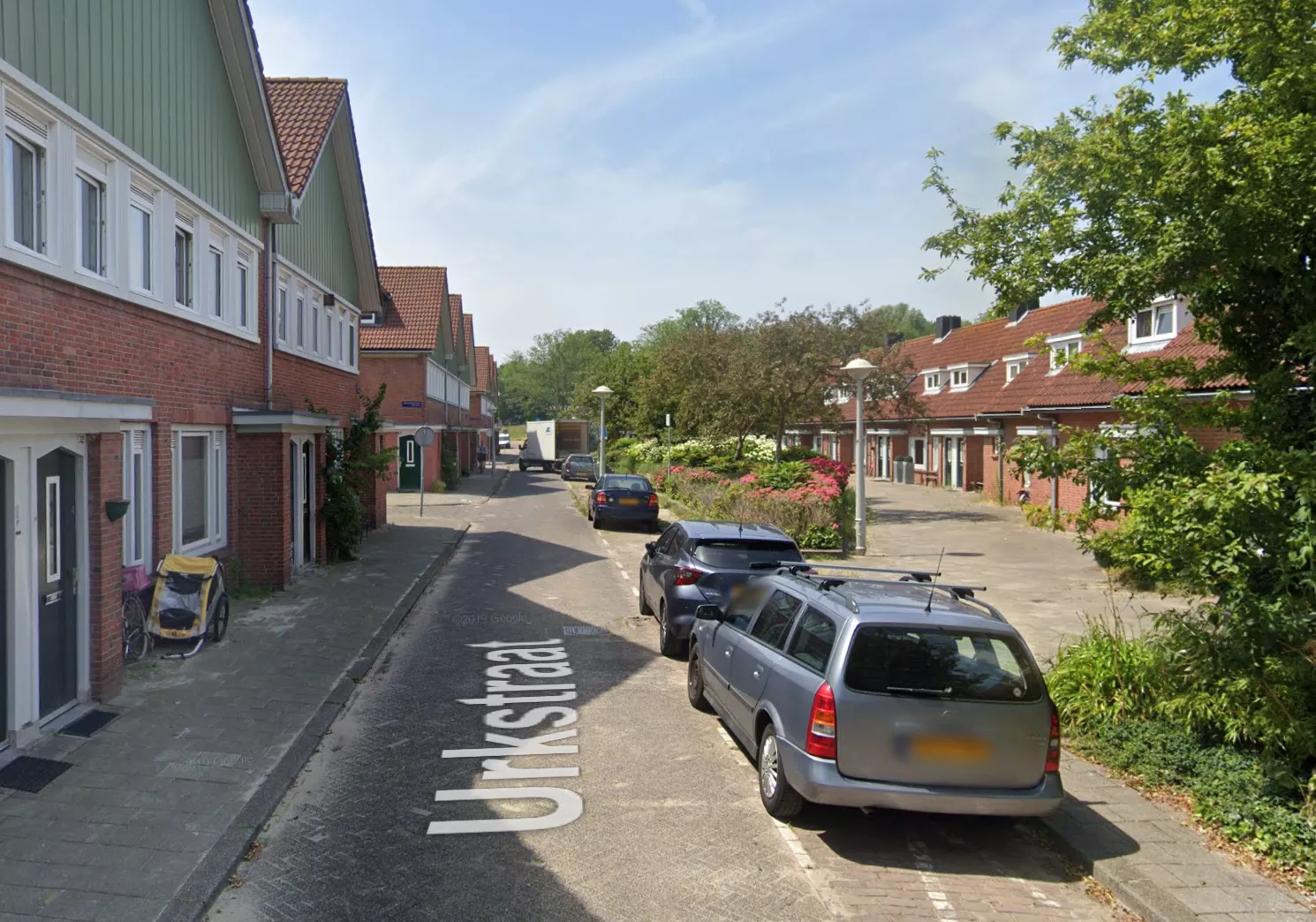 Politievoertuigen en afzetlint in de Urkstraat in Amsterdam-Noord na het steekincident.