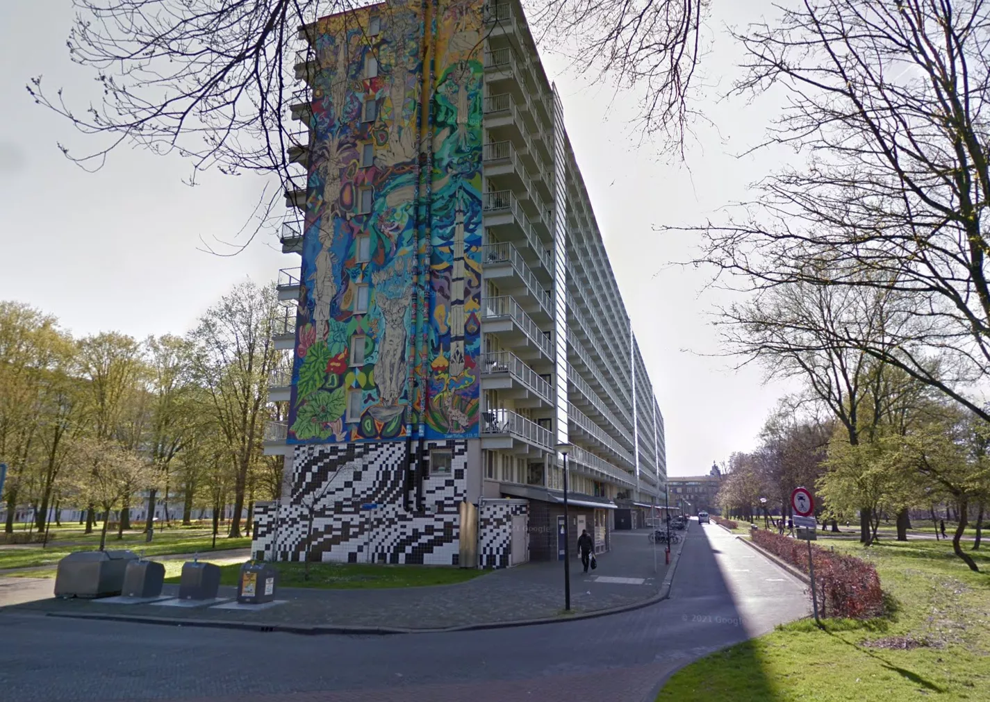 Een politievoertuig geparkeerd op straat bij het complex aan Haag en Veld in Amsterdam-Zuidoost, waar de steekpartij in de woning plaatsvond.