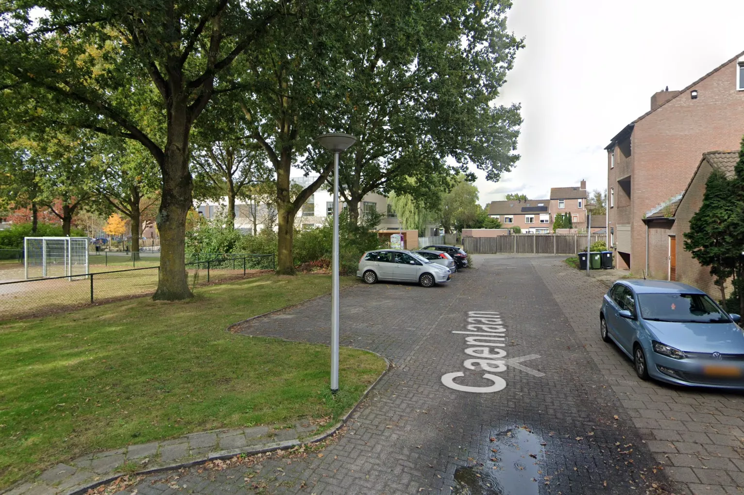 Een politievoertuig en afzetlint in een woonwijk ter illustratie van de locatie aan de Caenlaan in Eindhoven.