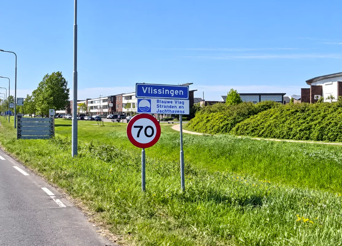 Blauw plaatsnaambord van de Zeeuwse stad Vlissingen bij de bebouwde kom.
