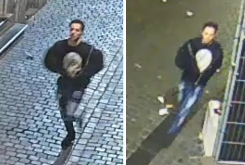 Opsporingsbeeld van een in het donker geklede verdachte die tijdens Koningsnacht in Breda een man bewusteloos sloeg in een snackbar.