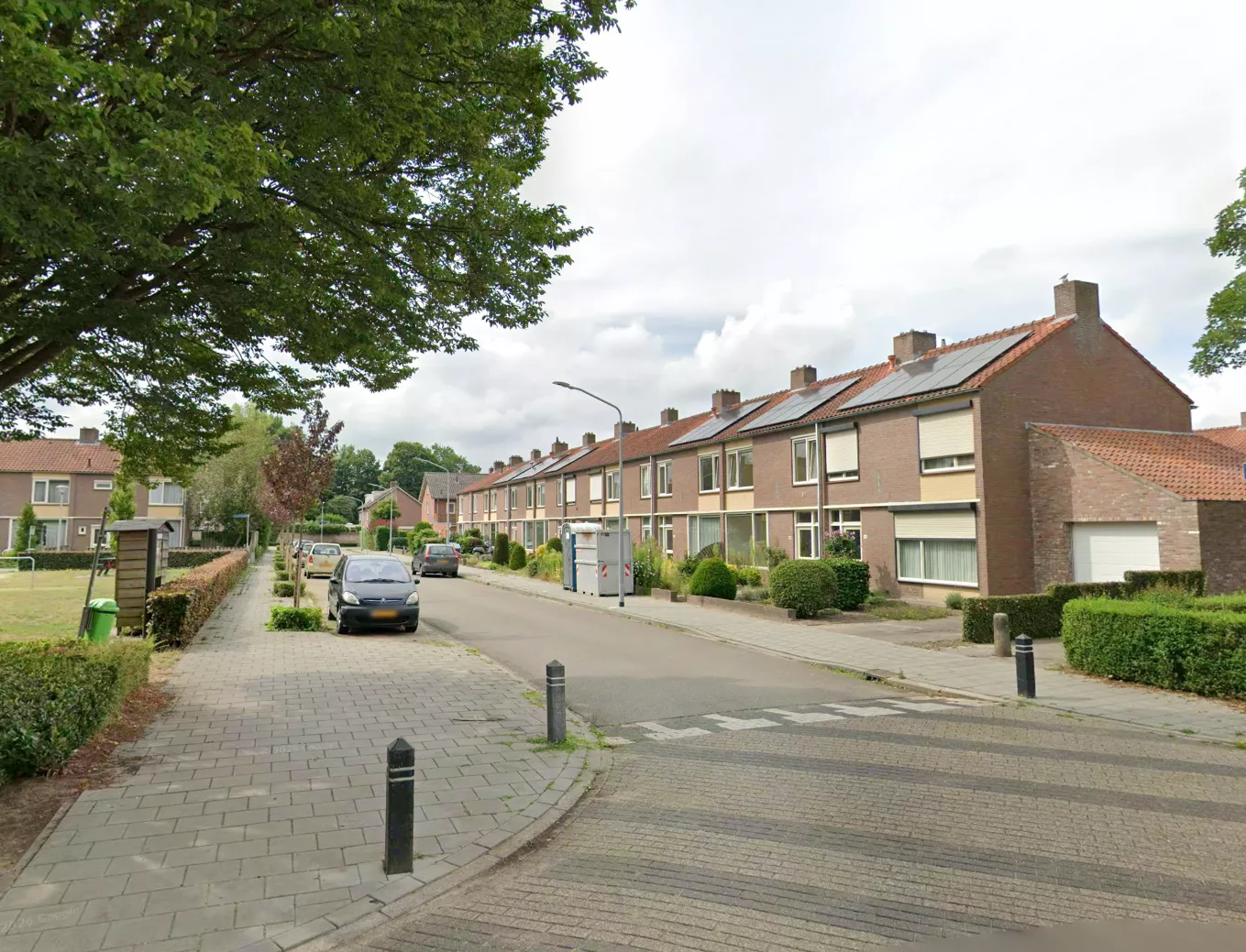 Beschadigde voordeur en ingeslagen raam van de woning aan de Abel Tasmanstraat in Valkenswaard na de politie-inval.