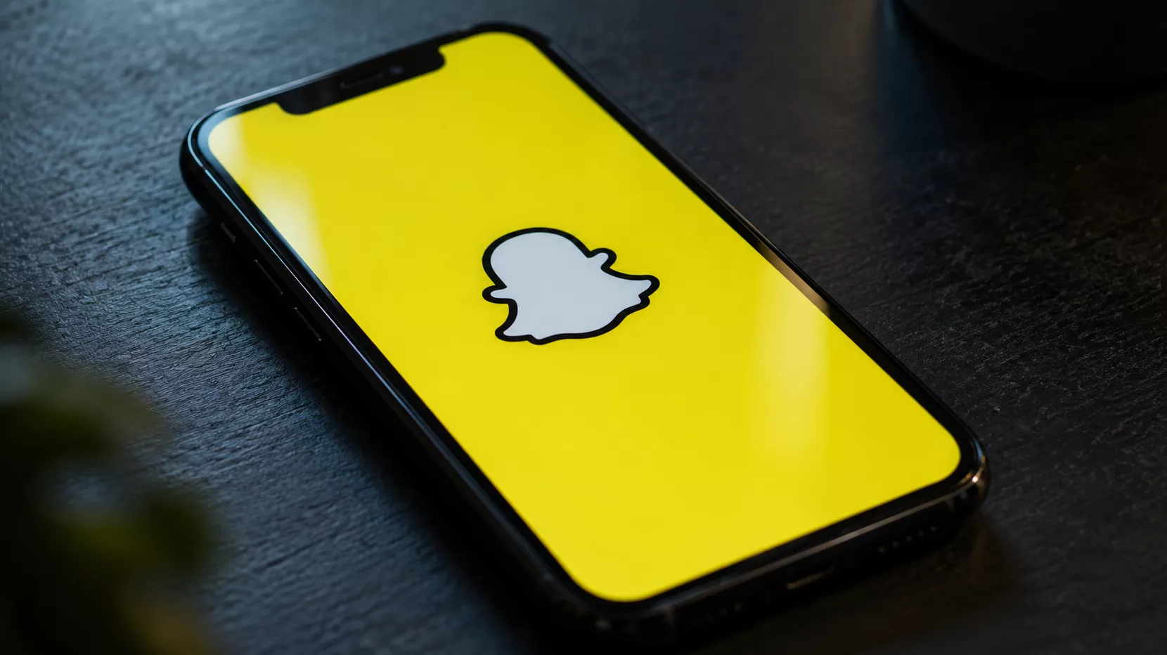 Een illustratieve foto van een smartphone waarop het gele Snapchat-icoontje zichtbaar is, de app die de verdachte gebruikte voor 'grooming'.