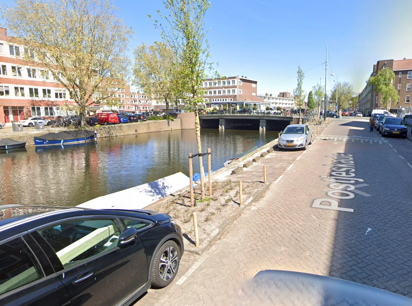 Meerdere hulpdiensten, waaronder de brandweer en politie, verzameld langs het water van de Postjeswetering in Amsterdam-West.