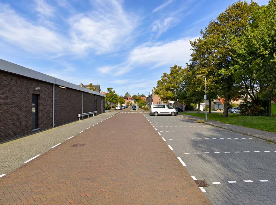 Politie-afzetlint en politievoertuigen op de parkeerplaats achter het winkelcentrum aan het Rederijkersplein in Noordwijk.