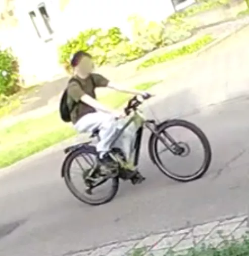 Geblurd camerabeeld van de verdachte jongeman op een groene elektrische fiets in Linne.